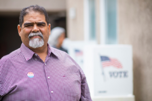 Stock image of a senior Latina at a voting booth.