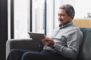 Shot of a senior man using a digital tablet on the sofa at home.