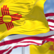 The New Mexico state flag waving along with the national flag of the United States of America