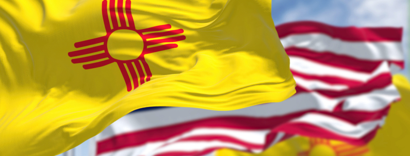 The New Mexico state flag waving along with the national flag of the United States of America